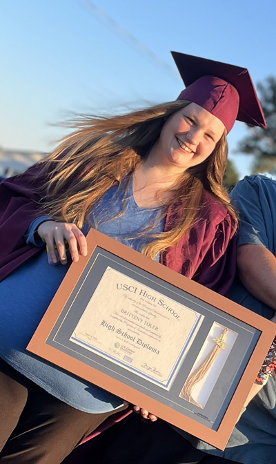 Graduate holding high school diploma